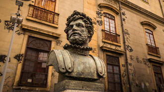 Desde o período colonial, a influência de Portugal foi fundamental na formação da literatura brasileira. Este artigo explora como a herança lusitana moldou nossa produção literária e destaca os autores portugueses que inspiraram escritores nacionais. Busto de Camões em frente ao Real Gabinete Português de Leitura, Rio de Janeiro, Brasil