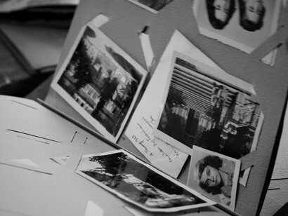Old photographs overlapping one another, symbolizing the fragmented nature of memory and the importance of preserving first hand traces of the past