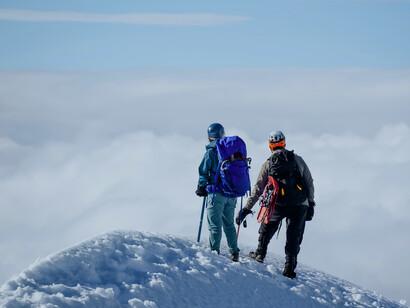 Personas en la cima de una montaña: creer en ti te hará desterrar esas creencias que te limitan