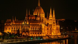 The Hungarian Parliament illuminated at night beside the Danube River, Budapest, Hungary