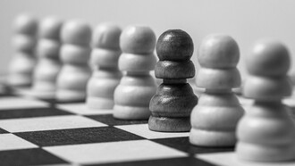 A solitary black pawn surrounded by a sea of white pawns on the chessboard