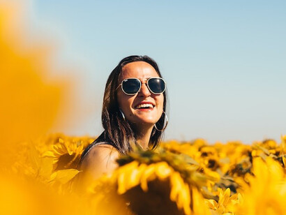 woman in black sunglasses on yellow flower field during daytime