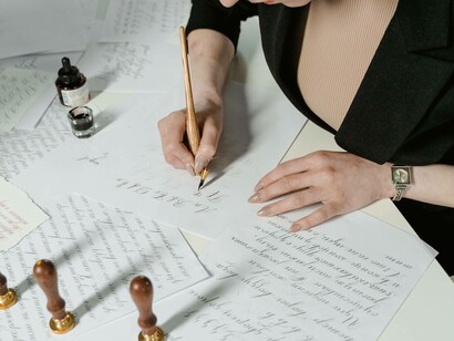 A woman writing with intent in the present chapter of her memoir