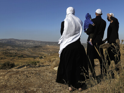 Clerics from the Druze community watch fighting taking place on the Syrian side of the Israeli