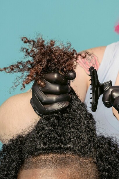 In professional settings... straightened hair was increasingly treated as the default marker of appropriate appearance. Relaxer companies transformed racialized beauty standards into a profitable industry, which depended on Black women repeatedly altering their hair