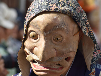 Un hombre con una máscara de Okina (anciano) en el desfile anual Menkake Gyōretsu en Sakanoshita, Kamakura.
"El hombre afeminado se enmascara de mujer.
El hombre que es político no necesita máscara!
