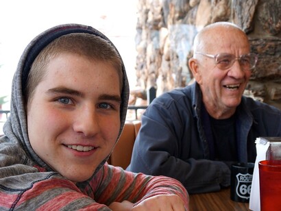 Nonno e nipote adolescente sorridenti a un tavolo