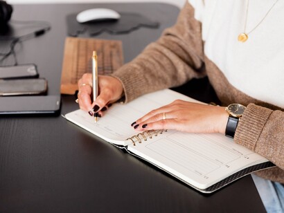 Mulher escreve em sua agenda