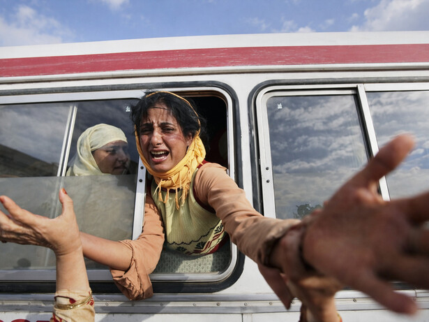 A distressed woman reaches out from a crowded bus, capturing a moment of urgency, separation, and human vulnerability amid crisis, Kashmir