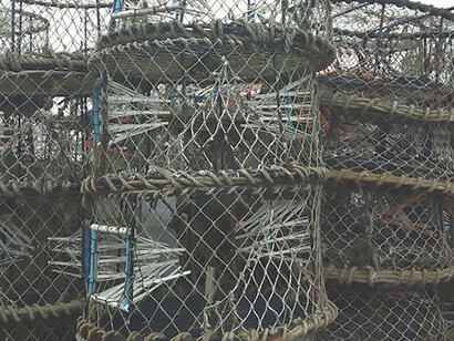 Worn crab traps are stacked in anticipation of fishing season in Bodega Bay, where the looming concerns of overfishing and fish nets persist, California, US