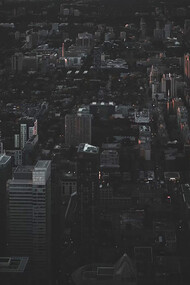 An aerial view of the city at night reveals a rare silence—its streets darkened by a widespread power outage