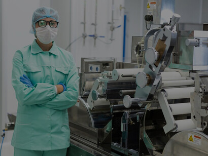 A scientist in a blue suit is standing near a manufacturing machine, illustrating the interconnected stages of food production, processing, and distribution