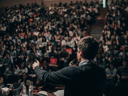 Uomo che parla al pubblico: la costruzione del contesto significante è particolarmente rilevante per una collettività