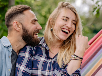 Close-up portrait of a loving couple relaxing on a hammock, expressing warmth, intimacy, and happiness