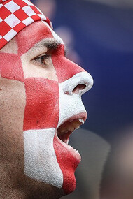 A passionate Croatia football supporter waves the national flag and cheers enthusiastically during an international football match, FIFA World Cup 2018 Final