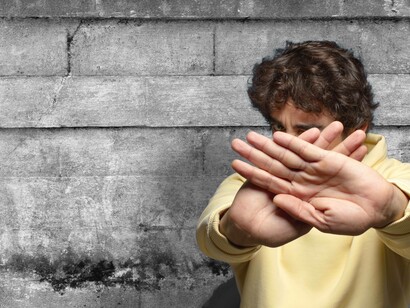 Ragazzo che allunga le braccia mettendo le mani una sopra all'altra in segno di protezione: "La prepotenza si smonta con la fermezza, con la lungimiranza, con la calma e la compattezza"
