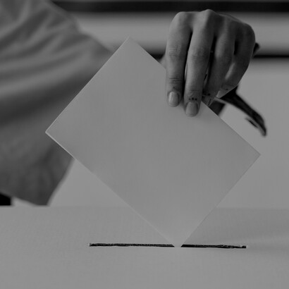 In a striking black-and-white image, a person casts their vote, highlighting the crucial role of citizen participation in shaping Chile’s political future