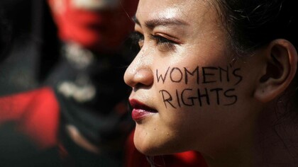 Woman protesting, on her face the writing: "Women’s rights". What is a woman?  
