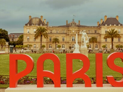 A promotional installation featuring a "Paris" logo in bold red letters; the Olympics embody the values of liberty, equality, and fraternity