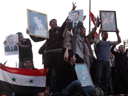 Opositores sirios muestran los retratos de sus oponentes