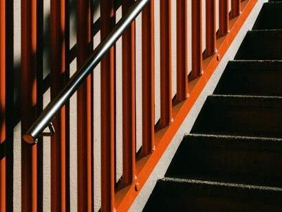 Escalier rouge et rembarde sur laquelle les consommateurs de services luxueux semblent s'appuyer pour atteindre leur groupe de référence