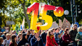 A man holding a 1.5 degrees celsius sign