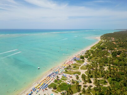A paisagem aérea evidencia o encontro entre o mar de águas rasas, a areia clara e a vegetação litorânea da Praia do Xaréu. Mais reservada do que outras praias da região, a chamada Praia da Bruna atrai quem procura desfrutar do litoral alagoano com mais tranquilidade