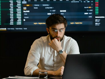 A trader studying live market data, representing the rise of passive investing