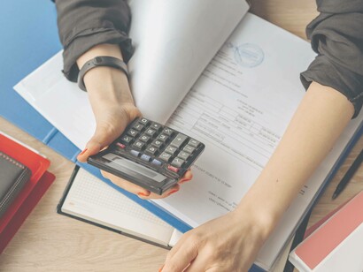 A woman uses a calculator to calculate tax