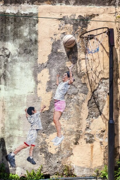 Two kids playing basketball during the day, wall art in George Town, Malaysia