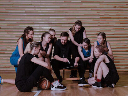 As the team gathers around their coach, this moment highlights the importance of both visionary leadership and tactical precision in achieving peak performance on the court