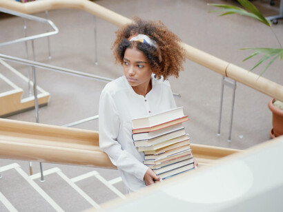 In the quiet of the library, this student's calm demeanor highlights the urgency of integrating universal wisdom into education to foster leaders who can address humanity’s critical problems