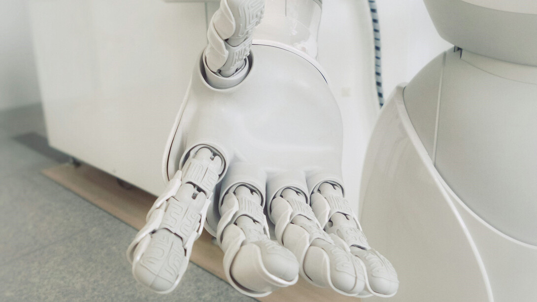 A white robot arm illustrates key themes in AI regulation, codes of practice, and AI governance, enhancing the visual representation of these concepts