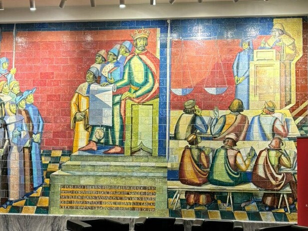 Painel cerâmico com obra de arte que representa a Fundação do Estudo Geral em 1290, situado ao fundo dos Passos Perdidos (no hall principal) da Faculdade de Direito da Universidade de Lisboa, datado de 1957, do pintor Lino António. Destacando as raízes medievais da Universidade de Lisboa, na figura do painel, D. Dinis segura o documento, ato este a que assistem o clero, a nobreza e cavaleiros, que haviam solicitado a criação do Estudo. À direita uma aula de Direito, com o Professor na sua cátedra, perante os seus alunos. Os dois painéis estão divididos por uma espada e uma balança, símbolos de justiça