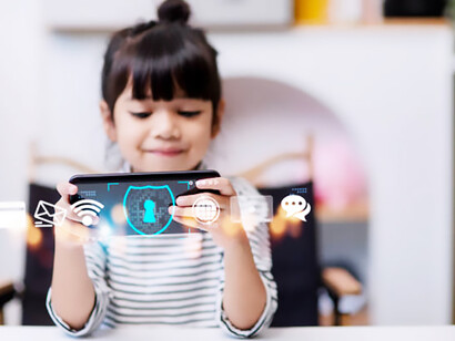 A child using a smartphone at home, with an internet-blocking app icon visible, representing online child safety, AI regulation, and cybersecurity measures for child protection