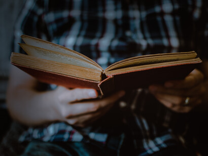 A boy studying a book, while sitting down
