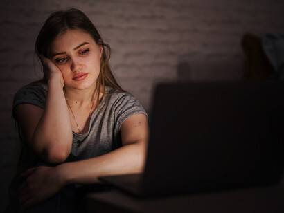 A stressed remote worker staring at her laptop, embodying the challenges of constant connectivity and endless notifications