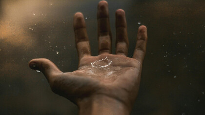A drop of water, rippling across a human hand