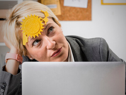 Portrait of a middle-aged businesswoman in the office, contemplating her summer vacation plans