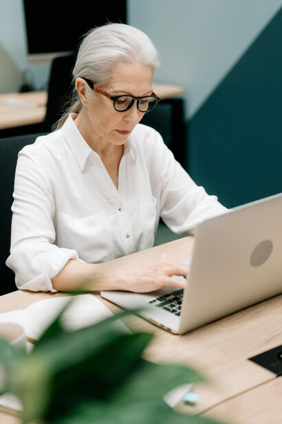 A senior woman working at her desk, focused and engaged
