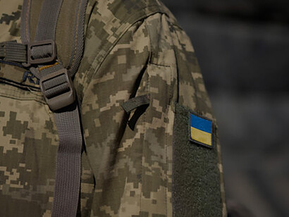 Decked in their distinguished military uniforms, Ukrainian servicemen proudly display the national flag and the coat of arms trident, signifying their unwavering dedication to the Armed Forces of Ukraine