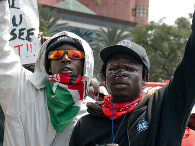 Kenyan youths chant as they carry flags during a vigil in memory of protesters killed during deadly nationwide demonstrations