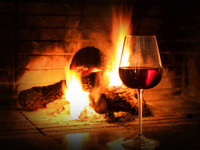 Copa de vino frente a una chimenea. El vino
mueve la primavera y crece como una planta la alegría