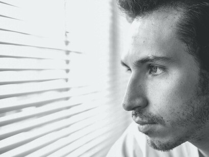 A person who has OCD and is struggling looking out a window 