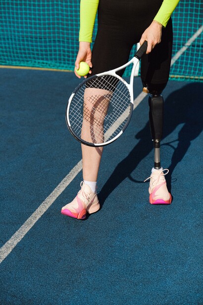 A person playing tennis on a blue court 