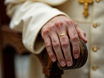 A gold-ringed hand grips ornate wood—symbolic of a Church clinging to power while the faithful ask for justice and reform