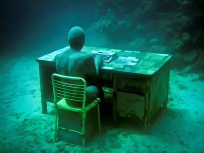 Jason deCaires. Hombre en escritorio