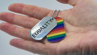 A person holding a rainbow tag in their hand, symbolizing the equality