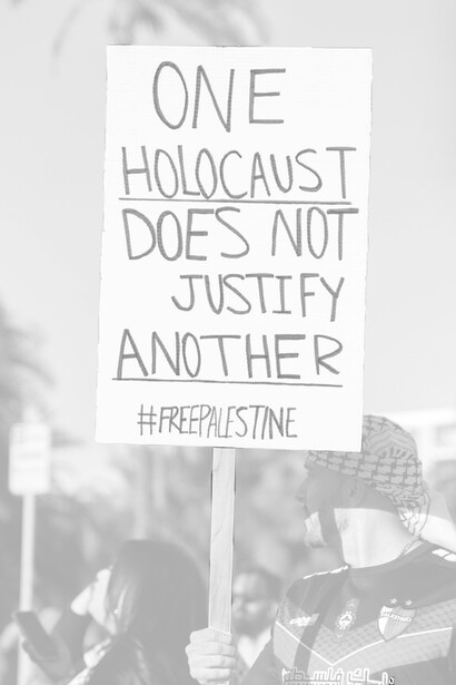 Protesters holding signs calling for the war against Palestine to be put to an end