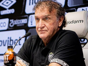 Cuca participa de entrevista coletiva na Vila Belmiro, vestindo a camisa do Santos. A experiência acumulada em diferentes clubes brasileiros é parte das credenciais que cercam seu retorno ao comando da equipe